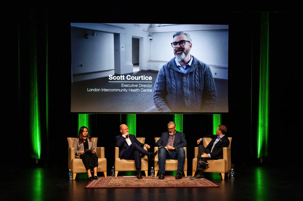 four people sitting in chairs on a stage