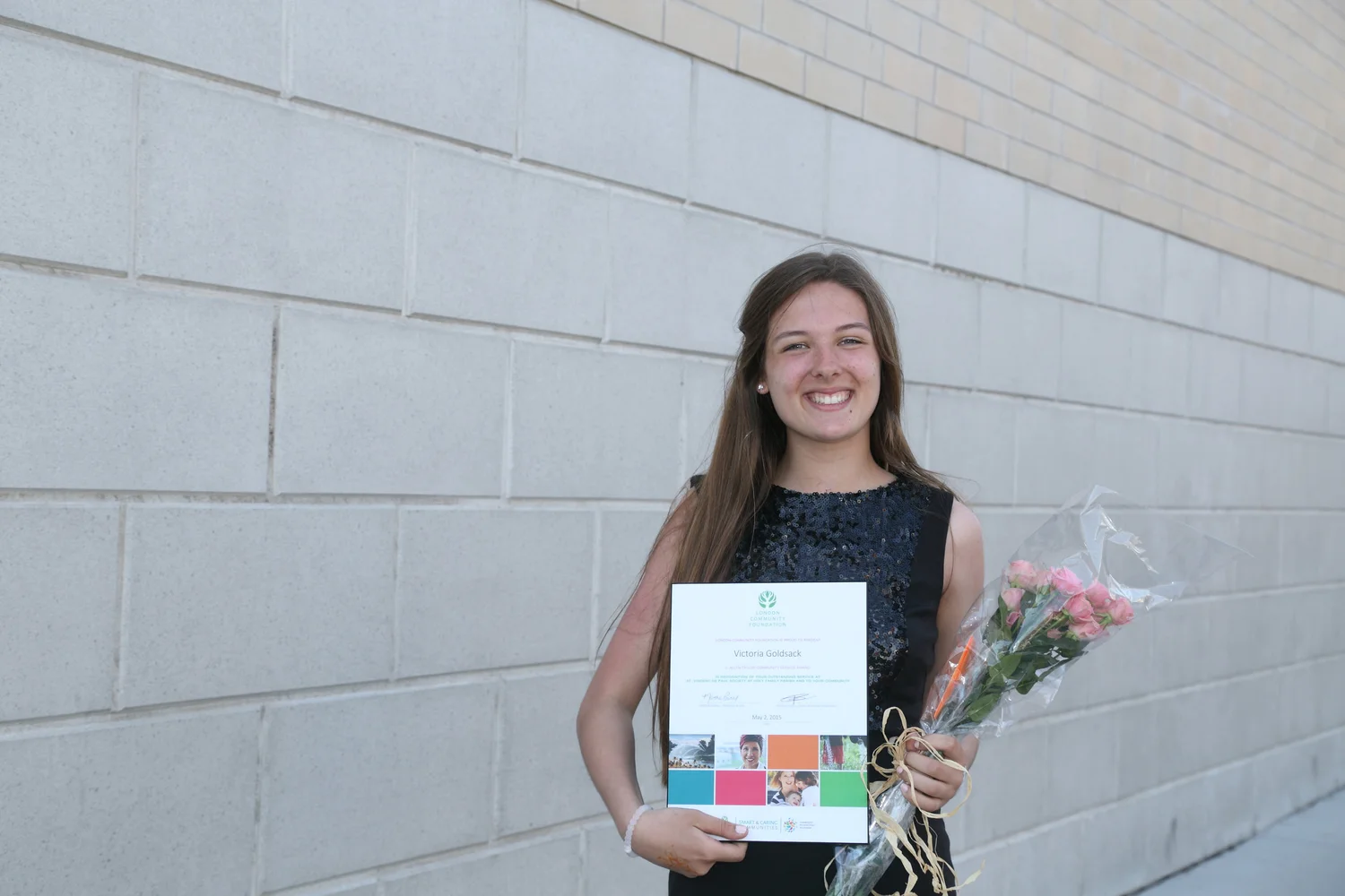 teenager holding award certificate and flowers