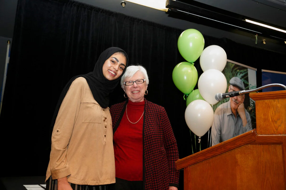two women smiling behind a lectern