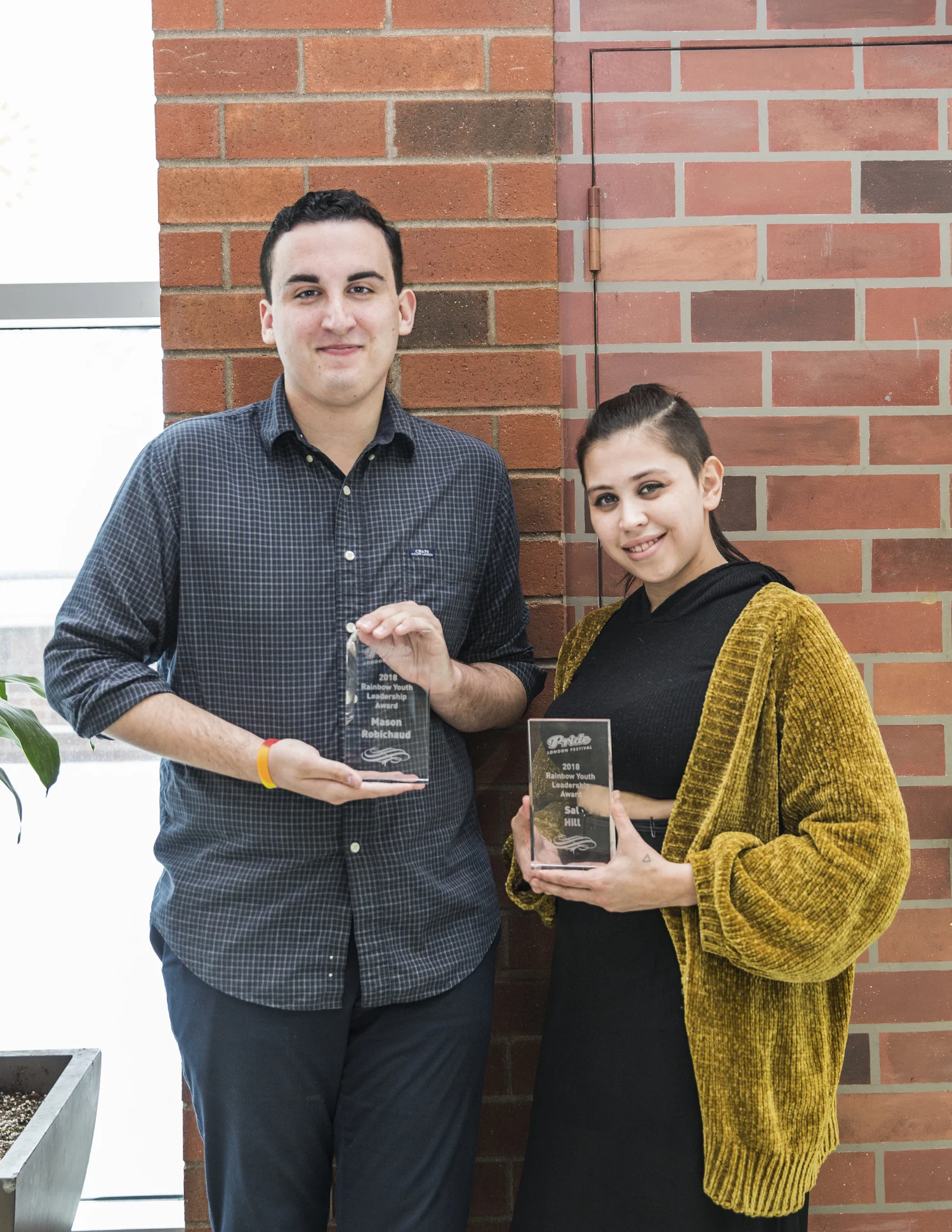 Two people holding their awards