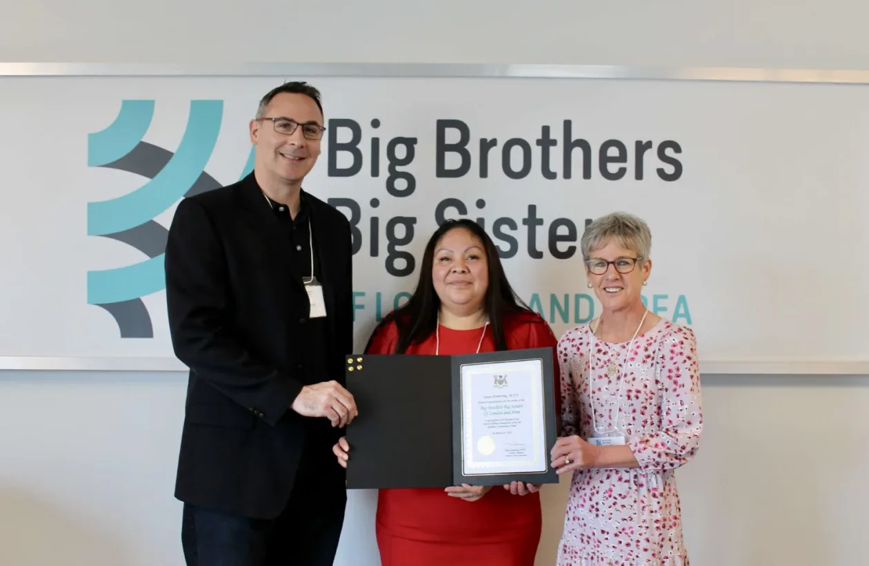 Three people holding an award
