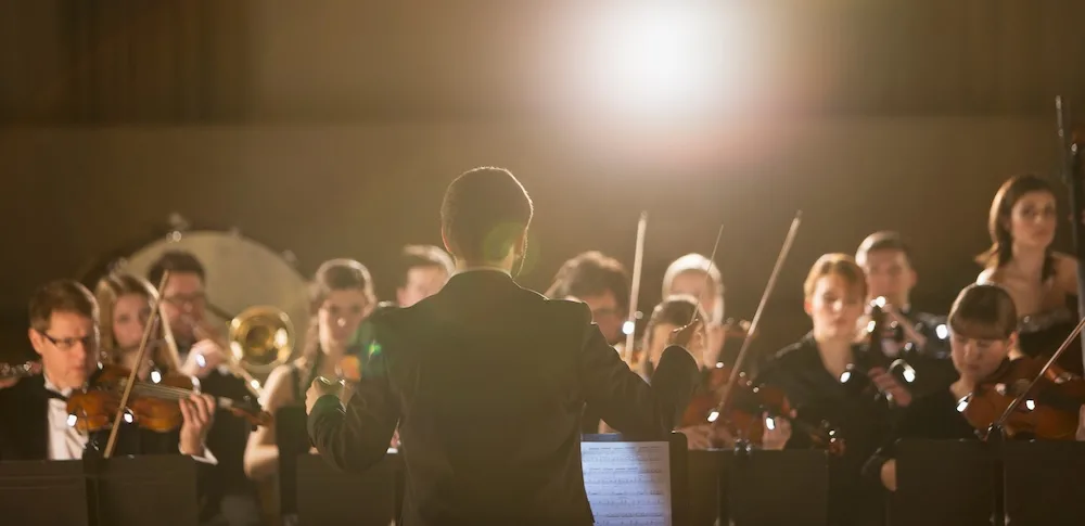 A conductor conducts an orchestra