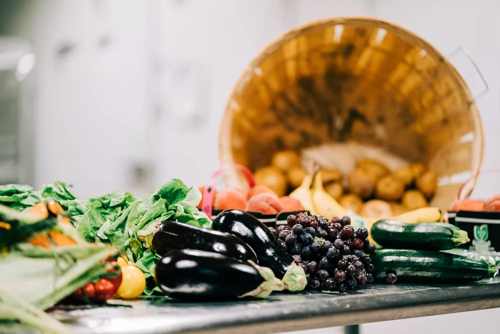 a basket of various vegetables spilling out onto a table