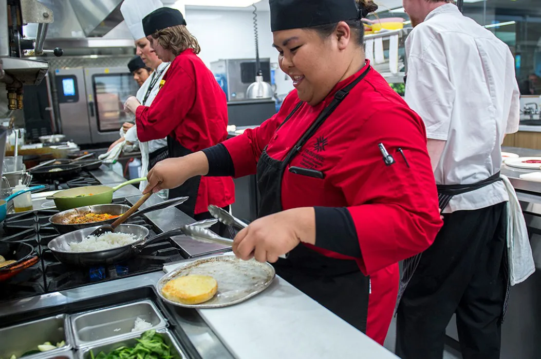 A kitchen with several people preparing food