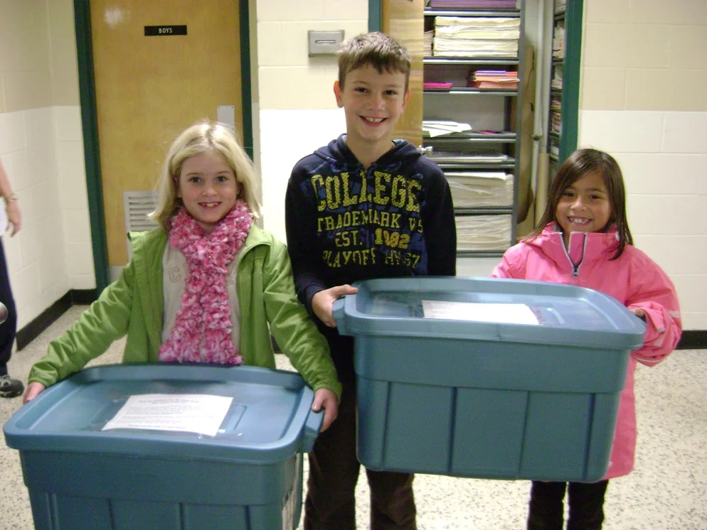three children holding plastic bins