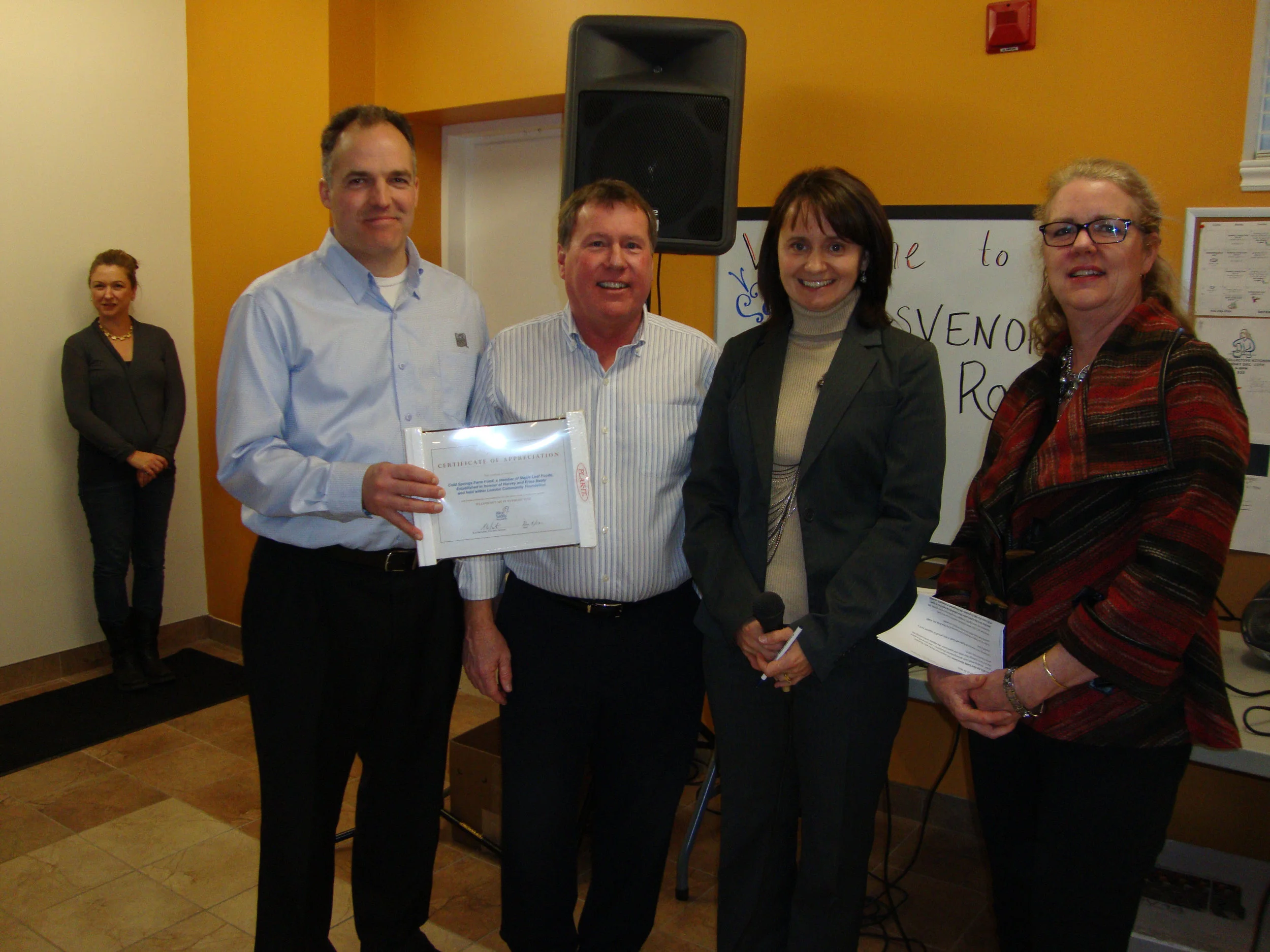four people showing off an award