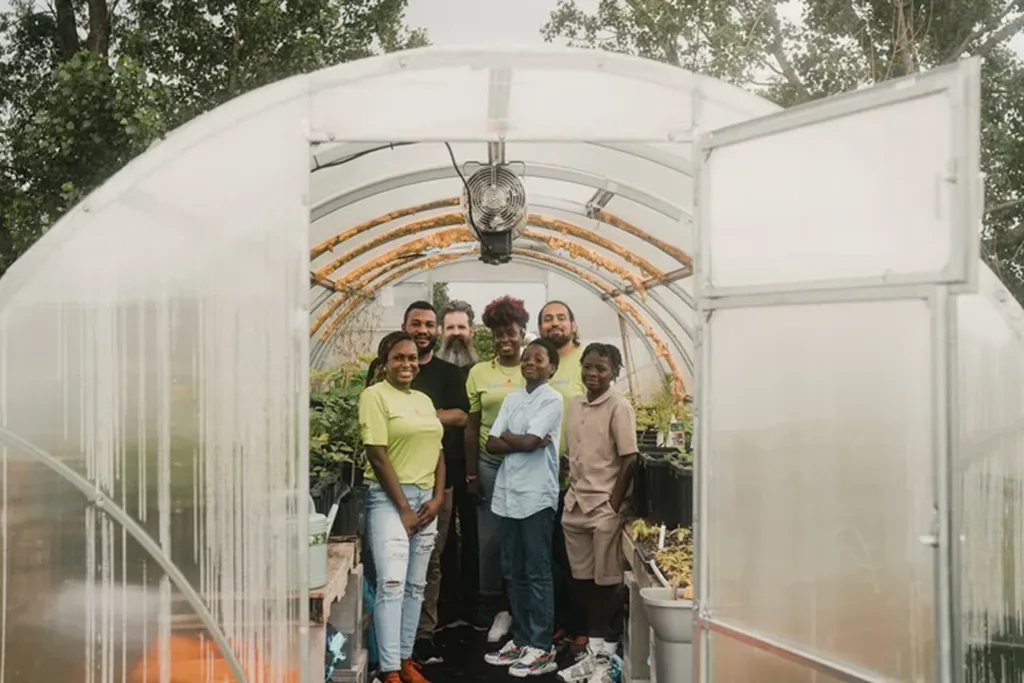several people standing inside a greenhouse